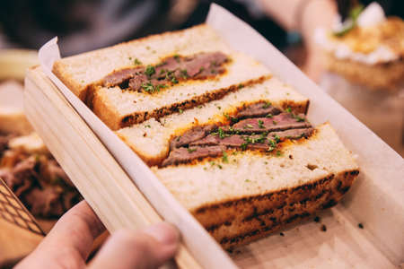 Close up of Japanese medium rare Wagyu sandwich served in wooden box.の写真素材