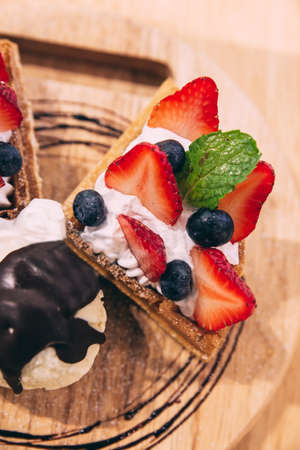 Waffles topping with slices of strawberry