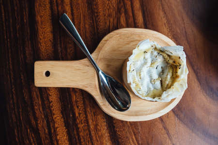 Top view of Brie cheese on wooden board on wooden table