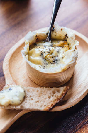 Close up Brie cheese on wooden board on wooden tableの写真素材
