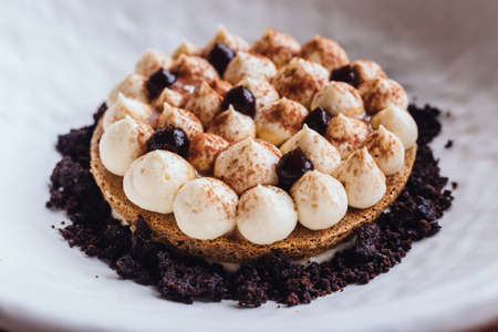 Creative dessert: Thin cream biscuit topping with cream, cocoa powder and chocolate crumble.の写真素材