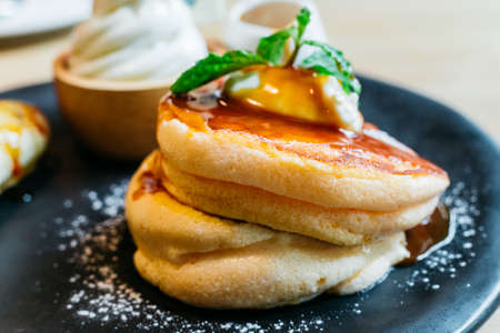 Close up Fluffy pancakes served with caramel banana, ice cream and syrup.の写真素材