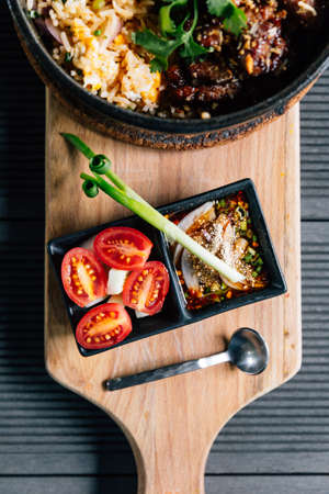 Top view of Thai style grilled pork fried rice served with Thai spicy dipping sauce.