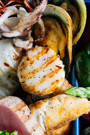 Seafood mixed grilled such as fish, squid, prawns, mussels and vegetables served with sweet and sour sauces.の写真素材