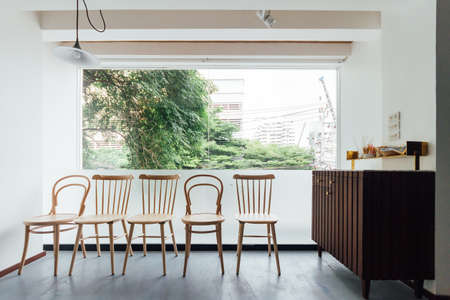 Minimal bread cafe decorating with white wall and wooden chairs. Warm, cozy and comfortable.