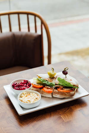 Grilled chicken sandwich made with homemade bread, tomato and lettuce served with beetroot salad and...