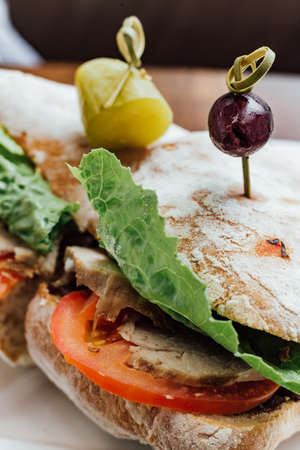 Grilled chicken sandwich made with homemade bread, tomato and lettuce served with beetroot salad and coleslaw.の写真素材