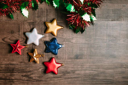 Metallic stars with Christmas ornament on wooden background. Flat lay for Christmas and happy new year bannerの写真素材