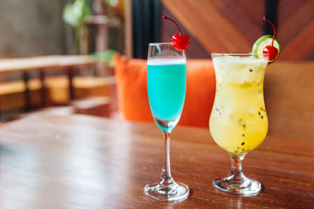 Turquoise color cocktail and passion fruit cocktail served with fresh cherry.の写真素材