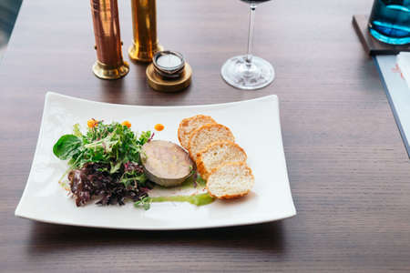 Canape with foie gras pate and salad served with white wine.の写真素材