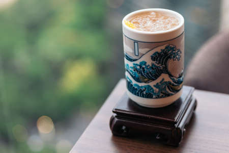 Iced plum wine (Umeshu) cocktail served in ceramic glass painted Japanese blue wave with blur background.の写真素材