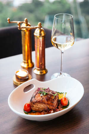 Baked juicy chicken breast and crispy skin with tomato and lemon served with white wine.の写真素材