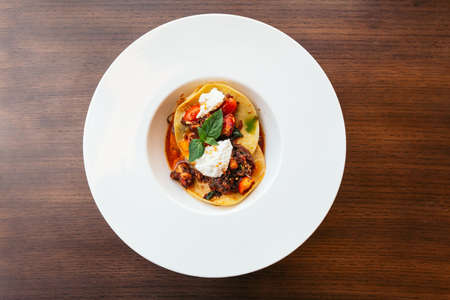 Ravioli with ricotta cheese and tomato served in white plate.の写真素材