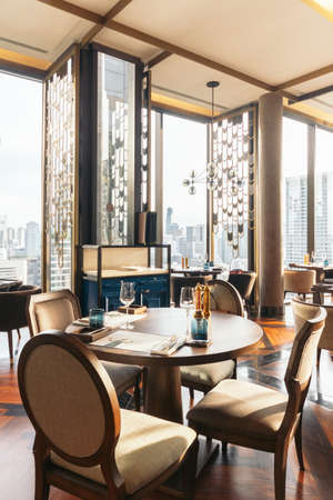 Modern luxury decorated interior restaurant that can view Bangkok cityscape. Elegant design for fine dining.のeditorial素材