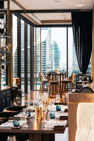 Modern luxury decorated interior restaurant that can view Bangkok cityscape. Elegant design for fine dining.のeditorial素材