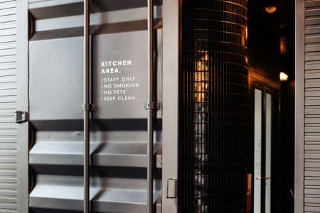 Modern pastry kitchen entrance made from container and decorated in black.