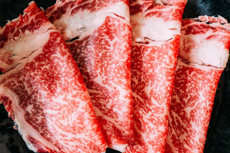 Close up Sukiyaki set including rare slices Wagyu A5 beef with high-marbled texture in black plate.の写真素材