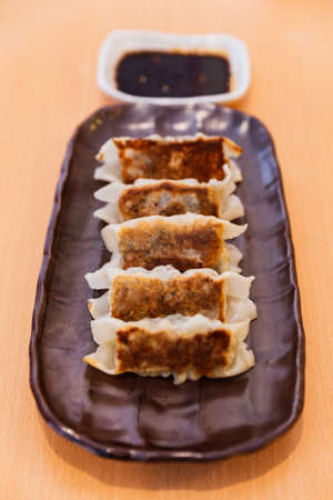 Gyoza (Japanese Pan-Fried Dumplings) served with sauce and sesame oil.