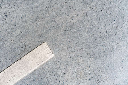 Outdoor road with 45-degree rotated white marking line on the left side texture. Perfect for background.の写真素材