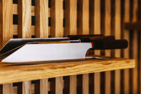 Japanese cook's knife stainless steel blade smooth pattern, Damascus style kitchen knife texture on wooden shelf.の写真素材