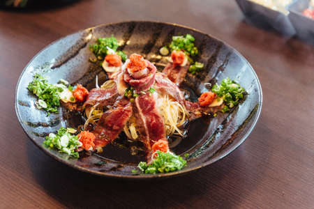 Rare slice A5 Wagyu with minced scallion, daikon in shoyu sauce.の写真素材
