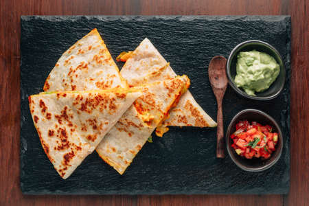 à¸ºBaked Chicken and Cheese Quesadillas served with Salsa and Guacamole on stone plate.の写真素材