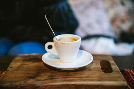Empty shot glass of Arabica Espresso with coffee stain served on wooden board.の写真素材