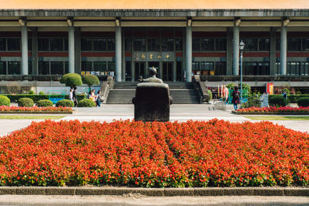Front of National Dr. Sun Yat-Sen Memorial Hall. Yellow rooftop and close up sculpture in rectangle red flowers area with tourist take a photo in Taipei, Taiwan.のeditorial素材
