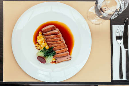 Top view of Roasted Duck Breast with cream of corn and tamarind poultry jus, Served with bread and butter.の写真素材