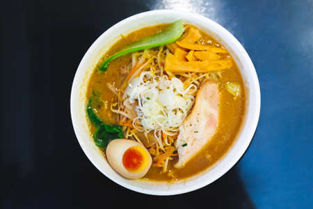 Top view of Ramen Pork Bone Soup (Tonkotsu Ramen) with Chashu Pork, Scallion, Sprout, Carrot, Menma (Seasoned Bamboo Shoots), Dried Seaweed and boiled eggs.の写真素材