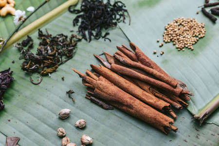 Fresh cinnamon and many spices on banana leaves. Example of spicy and aromatic taste of coffee.
