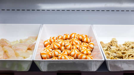 Close up fish meat, Salmon fish ball and pig offal in fresh foods line for sukiyaki buffet in...