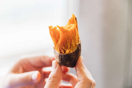 Close up Baked Sweet Potato with peel in hands, hot and sweet in Taiwan, Taipei.の写真素材