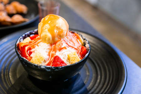 Bingsu, a Korean shaved ice dessert with sweet toppings such as vanilla ice cream, cheese cube and sweetened condensed milk. It's very popular dessert.の写真素材