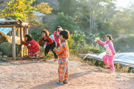 Thai northern kid wearing pyjamas standing with sunlight and her friends in the background in the Akha village of Maejantai on the hill in Chiang Mai, Thailand.のeditorial素材