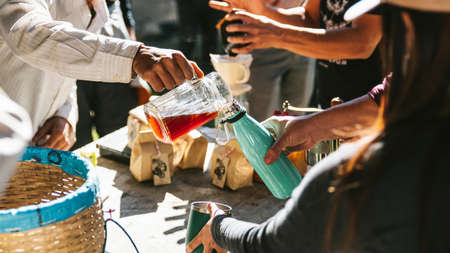 Man pouring hot drip coffee in temperature bottle for the other in the Akha village of Maejantai on the hill in Chiangmai, Thailand.の写真素材