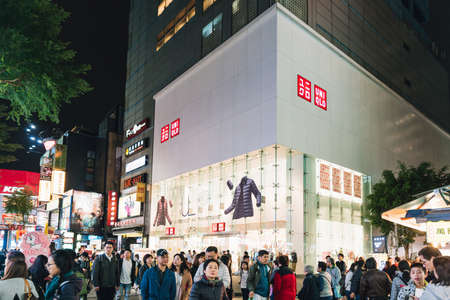 People walking around with white and other commercial buildings in the background in Ximending area in Taiwan, Taipei.のeditorial素材