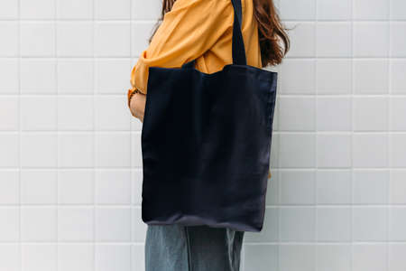 Woman is holding black bag canvas fabric for mockup blank template.の写真素材