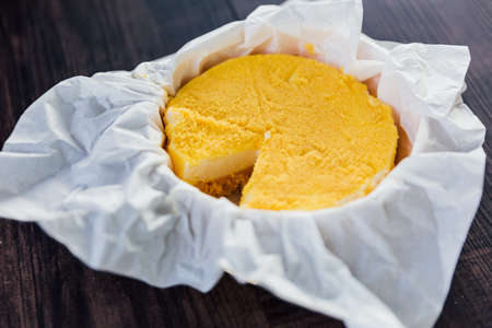Close-up Mascarpone CrÃ¨me Brulee Cheesecake with missing slice, smooth, rich milky taste on paper...