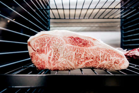 Premium Rare Sirloin Wagyu A5 beef with high-marbled texture inside refrigerator.の写真素材