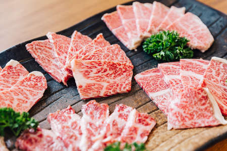 Close-up Premium Rare Slices many parts of Wagyu A5 beef with high-marbled texture on stone plate served for Yakiniku (Grilled Meat).の素材 [FY310131816332]