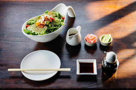 Japanese salad with avocado, tomato, green oak, almond and sesame topping sesame salad dressing. Served with pickled ginger and wasabi.の写真素材