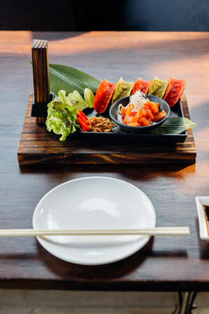 Raw Salmon Spicy Salad served with red and green crispy chips for canape .
