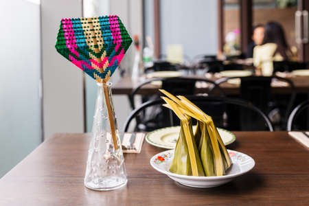 Colorful weaving hand fan and Steamed flour with coconut filling. Thai dessert wraps with banana...