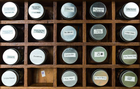 Top view of various dry flower tea glass bottles with aluminium lid inside wooden box.の写真素材