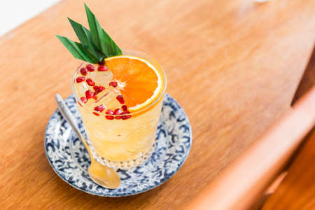 The orange fruity cocktail that mix with sliced orange and pomegranate pulps in a drinking glass....