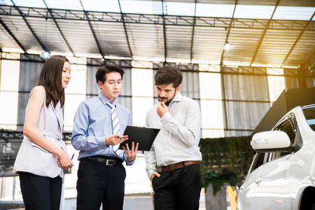 Car Dealership. The Asian Salesman (woman and man) checking the list with the middle east customer before hand over. Automotive Leasing and Dealing Business. International Business.の写真素材