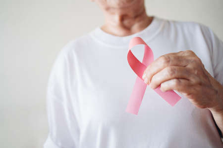 Senior woman hands support Breast Cancer Day by holding Pink Ribbon Breast Cancer Awareness with copy space. Healthcare and medicine concept. October Pink day. World Cancer Day.の写真素材