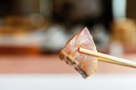 Japanese Omakase meal: closed up Aged Akami Tuna (Lean Tuna) pinching with chopsticks. Japanese luxury meal.の写真素材