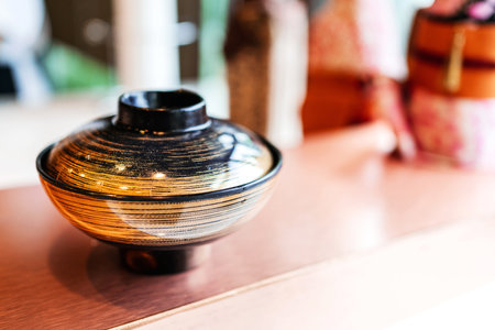 Japanese Omakase meal: Miso soup in miso black and gold color bowl close with a lid on the counter. Japanese traditional and luxury meal.の写真素材
